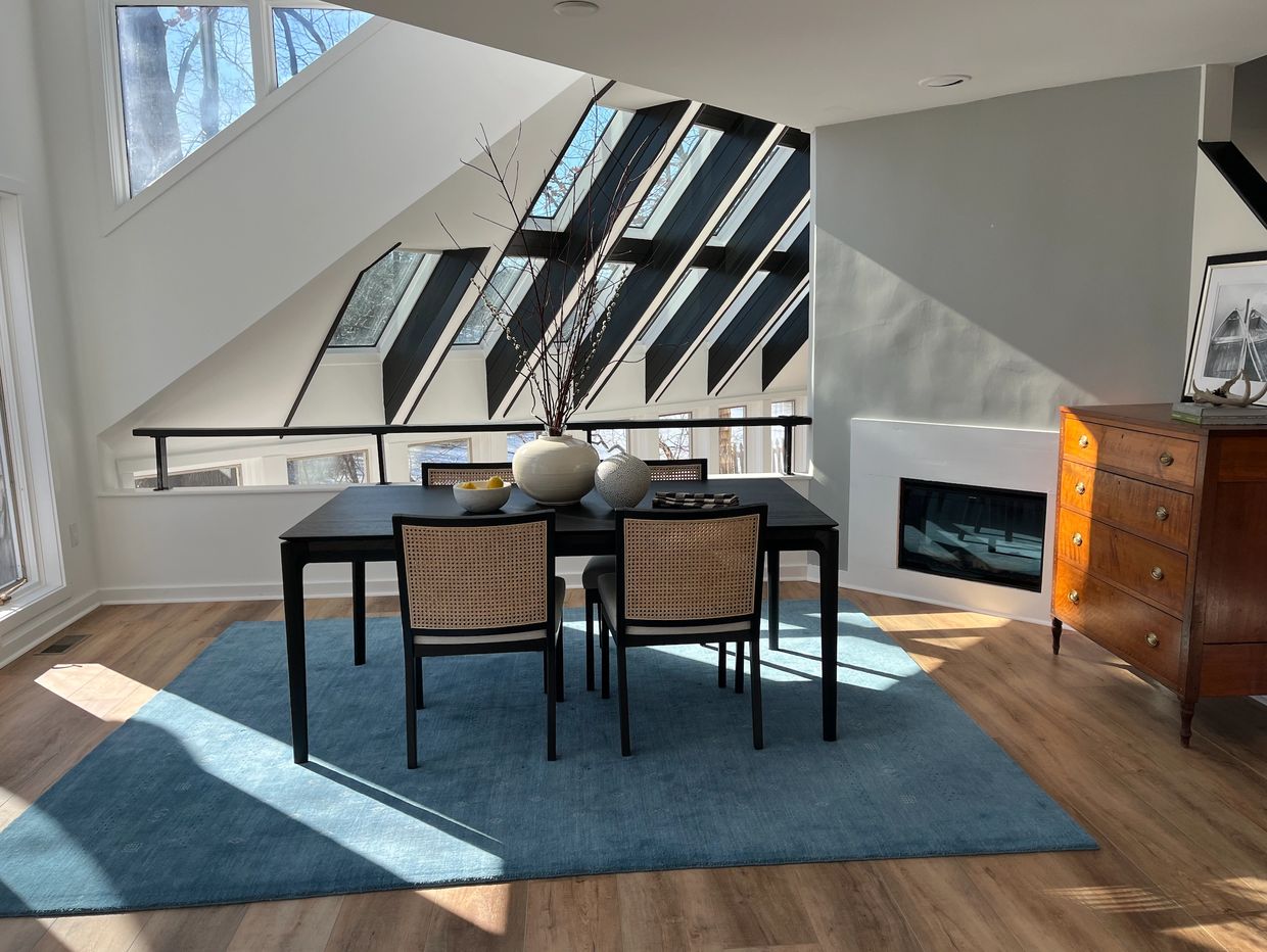 Black dining table surrounded by black and woven chairs