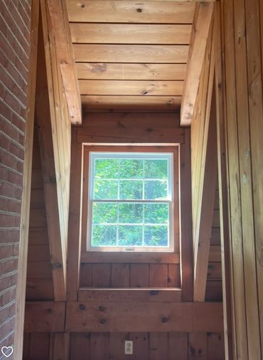 Windows let light in but the space is dark due to all of the wood