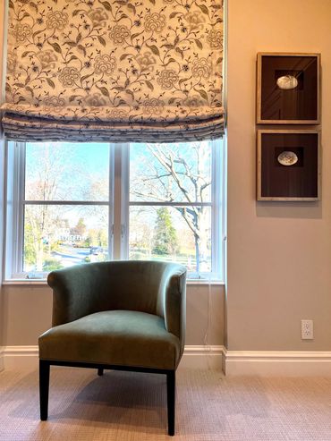 Guest room with custom roman shade in floral and velvet green chair