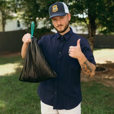 Man wearing a 'Poop Patrol' hat holding a trash bag and giving a thumbs up.