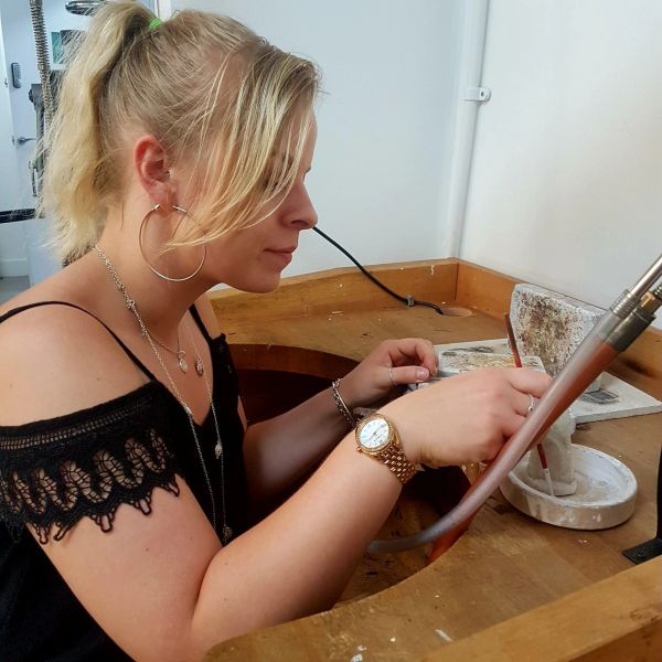 Woman working meticulously at a workbench.