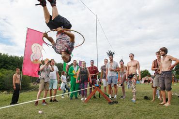 a man backflipping through a hula hoop in front of a crowd of people 