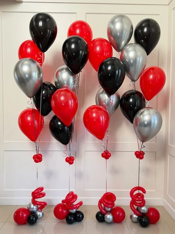 Cluster of red, black, and silver balloons indoors.