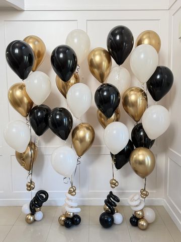 Elegant black, white, and gold balloons arranged indoors.