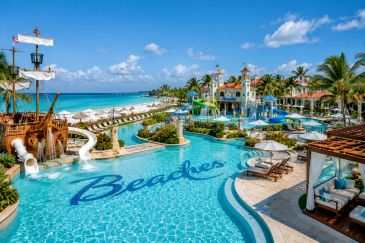 Luxurious beachside resort pool with waterslides and pirate ship theme.