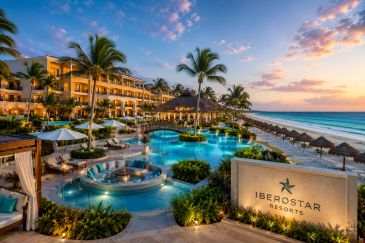 Luxurious Iberostar resort with pool, palm trees, and ocean view at sunset.