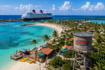 Disney Cruise ship docked at tropical Castaway Cay island beach.