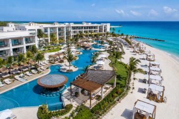 Luxury beachfront resort with pools and cabanas overlooking the ocean.