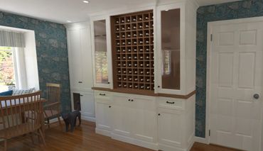 Elegant dining area with wine storage and floral wallpaper.