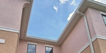 Two-story house with peach and tan exterior under a blue sky.
