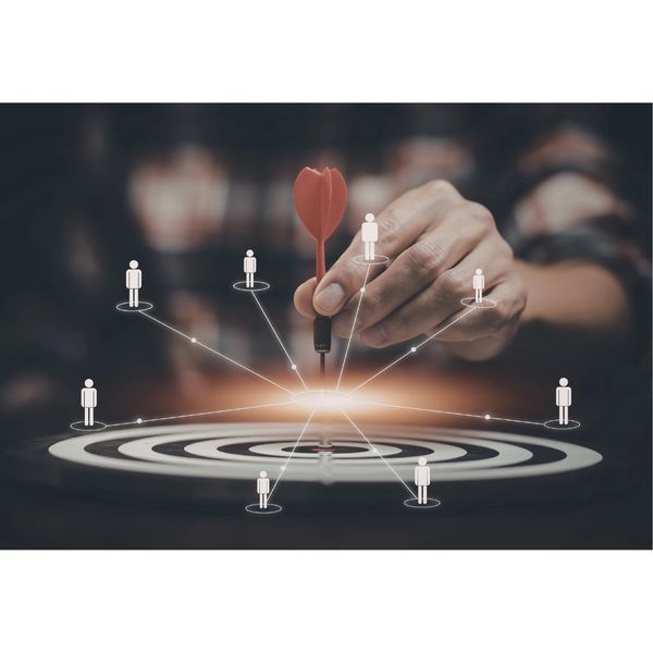 Hand placing a dart on a target surrounded by connected human icons.