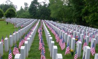 veterans cemetery with headstones and flags
