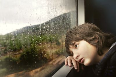 sad boy watching it rain
