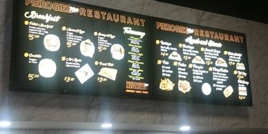 Menu boards of a pierogies restaurant showing various food and drink offerings.