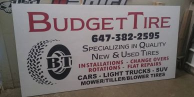 Signboard for Budget Tire offering tire services for various vehicles.