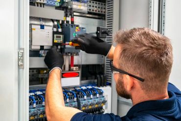 Electrician wiring an industrial panel.