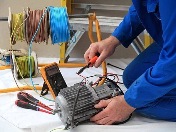 Hands adjusting wires on equipment.