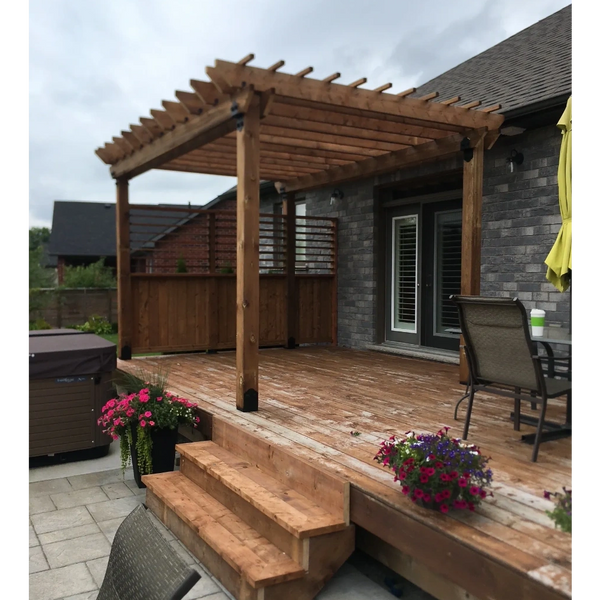 Wooden pergola on a backyard deck with flower pots and patio furniture.
