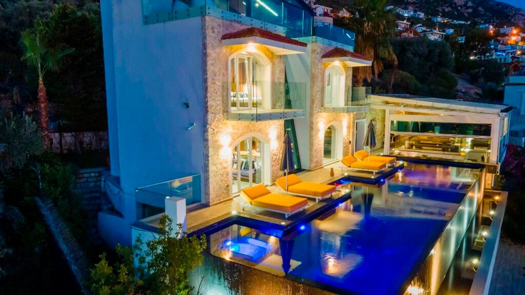 An external view of Villa Mavi manzara, Kalkan showing the sunbeds, pool, swim-up bar and terrace