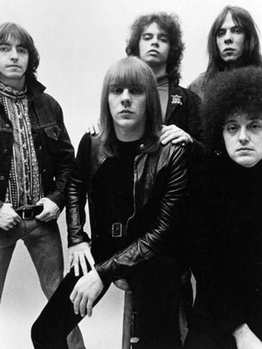 Black and white photo of a 1970s rock band posing together.