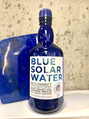 Hand harvested spring water in an upcycled blue glass bottle for maximum hydration with love