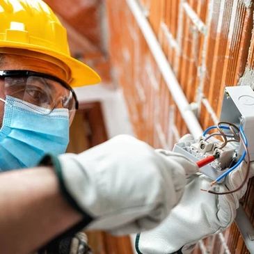 An electrician installing a device into the junction box