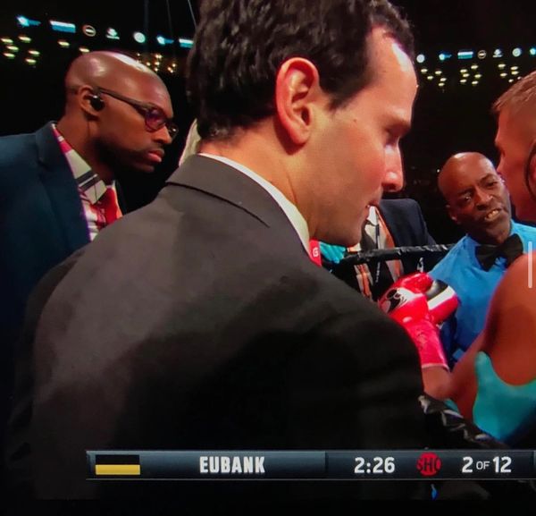 Dr. McKirven Ceus standing on the side of the boxing ring assessing an injured boxer