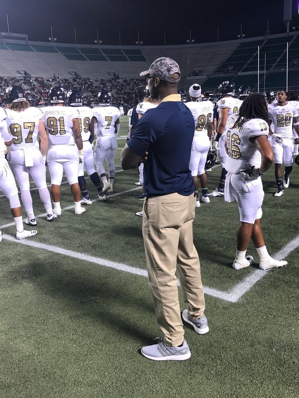Dr. McKirven Ceus, MD standing on the sideline at a football game