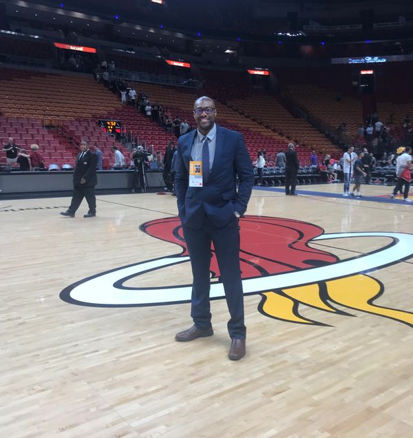 Dr. McKirven Ceus standing in the middle of the Miami Heat basketball court
