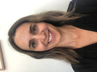 Smiling woman with shoulder-length hair wearing a black top.