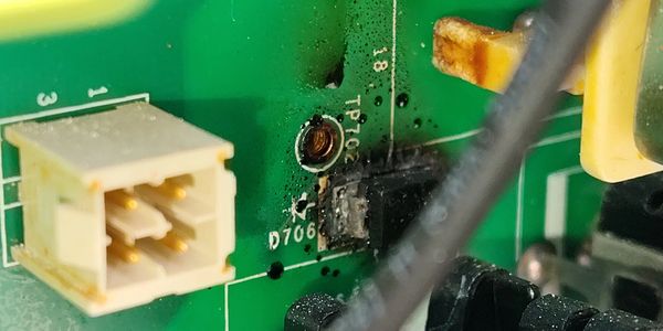 Close-up of a damaged circuit board with burned components.