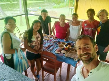Grupo de personas sonrientes en una reunión junto a mesa con artesanías.