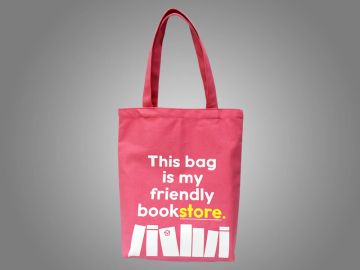 Pink tote bag with a friendly bookstore message and book graphics.