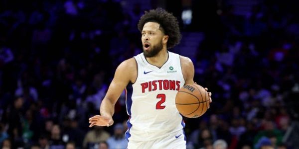 Basketball player from the Pistons dribbling the ball during a game.