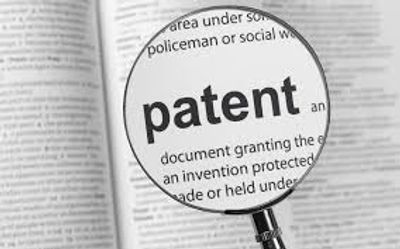 Magnifying glass highlighting the word 'patent' in a dictionary.