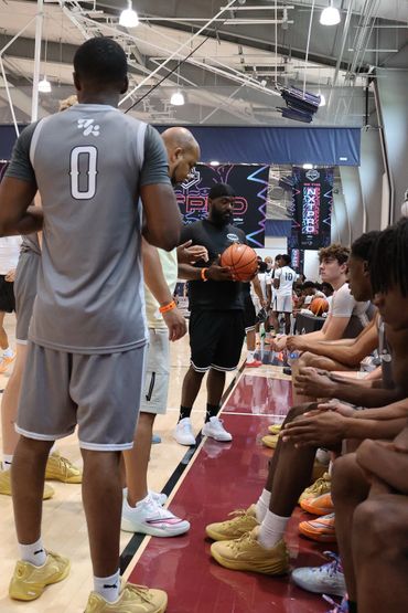 Basketball players and coach during a game break in an indoor court.