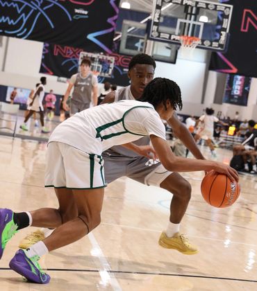 Two basketball players competing intensely in a gym.