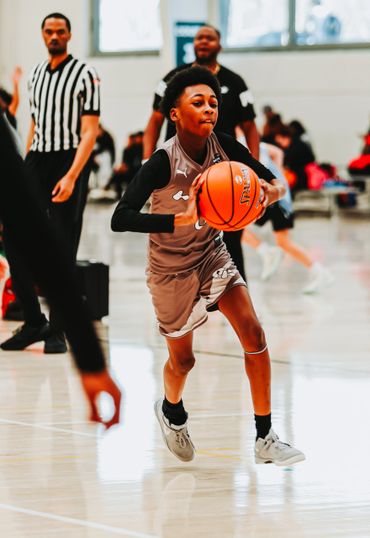 Young basketball player driving with the ball during a game.