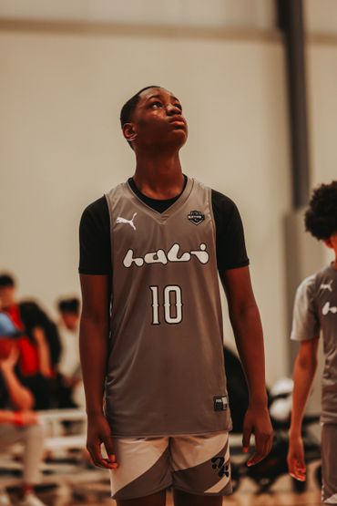 Young basketball player in a gray jersey looking upwards.