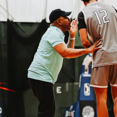 Coach giving basketball advice to player during practice.