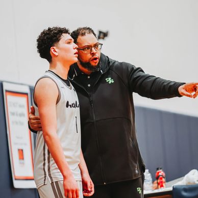 Basketball coach giving instructions to a player during a game.