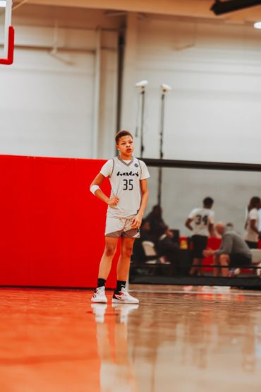 Young basketball player standing on court during a game.