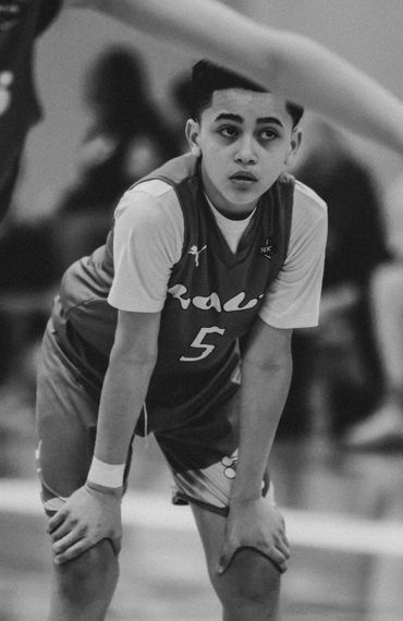 Young basketball player in jersey number 5 catching his breath during a game.