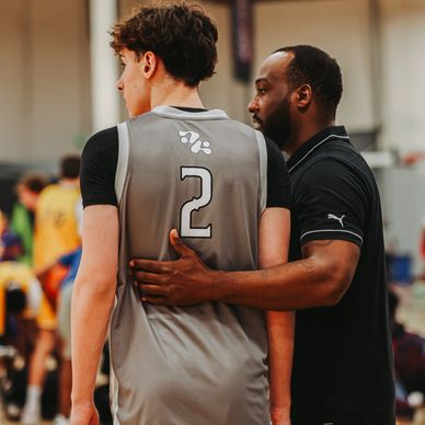 Coach advising basketball player during a game.