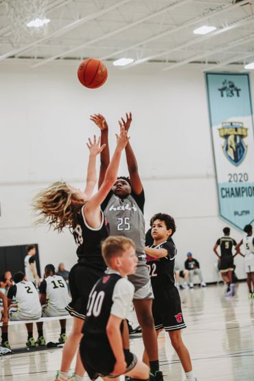 Youth basketball players competing intensely for the ball during a game.