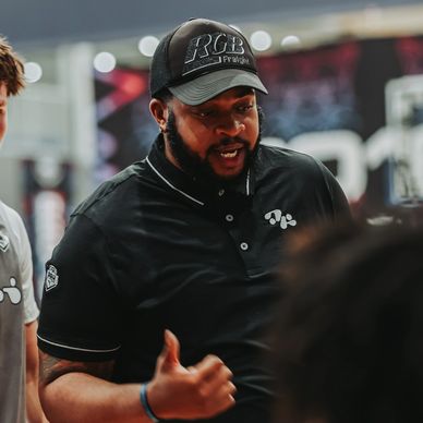 Basketball coach giving instructions to players during a game break.