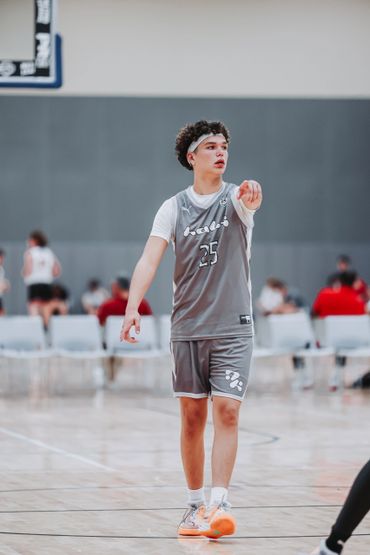 A basketball player in gray uniform pointing during a game.