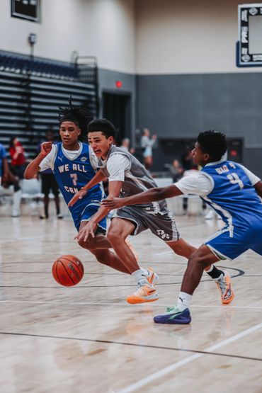 Young basketball players competing intensely for the ball on the court.