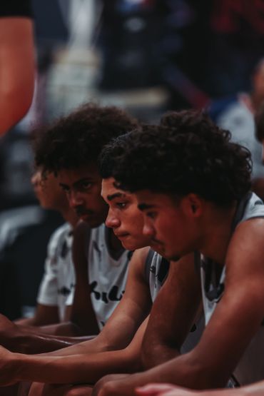 Focused basketball players sitting on the bench during a game.
