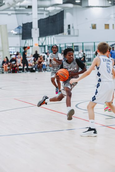 Youth basketball game with players in action on the court.